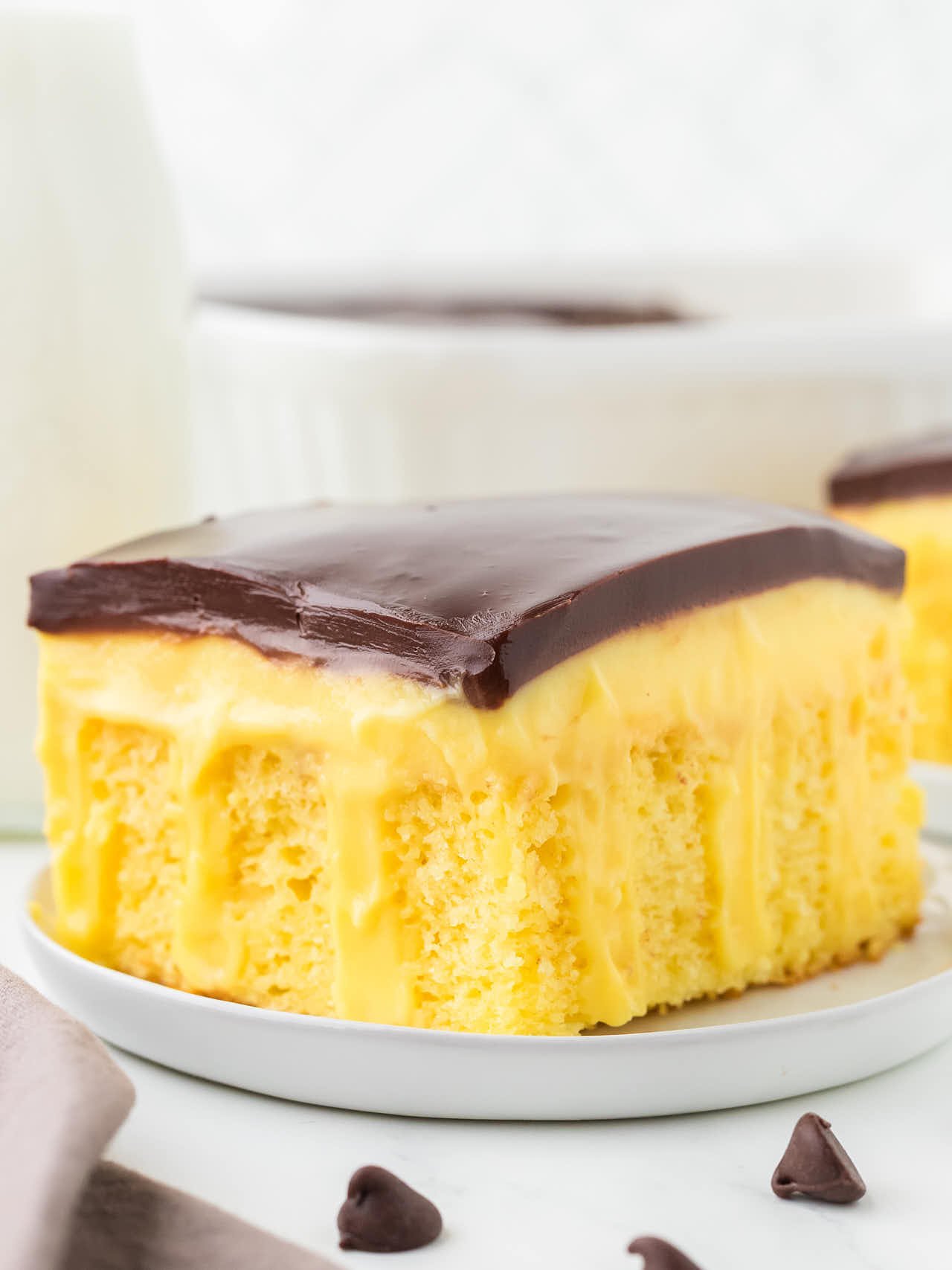 Boston Cream Poke Cake served on a white plate. 