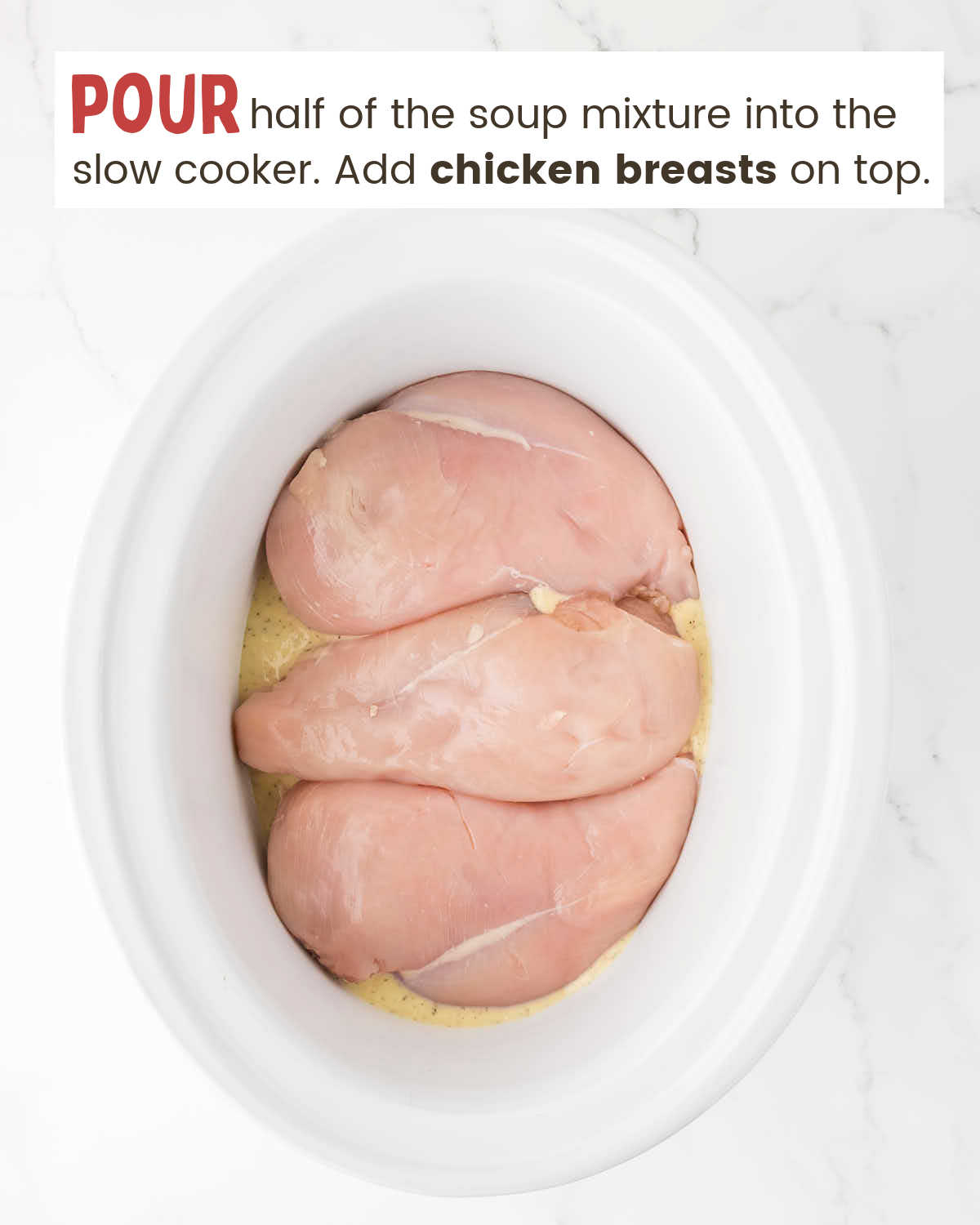 Three chicken breasts in a slow cooker.