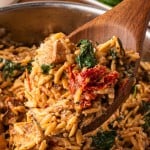 A wooden serving spoon filled with Marry Me Chicken Orzo.