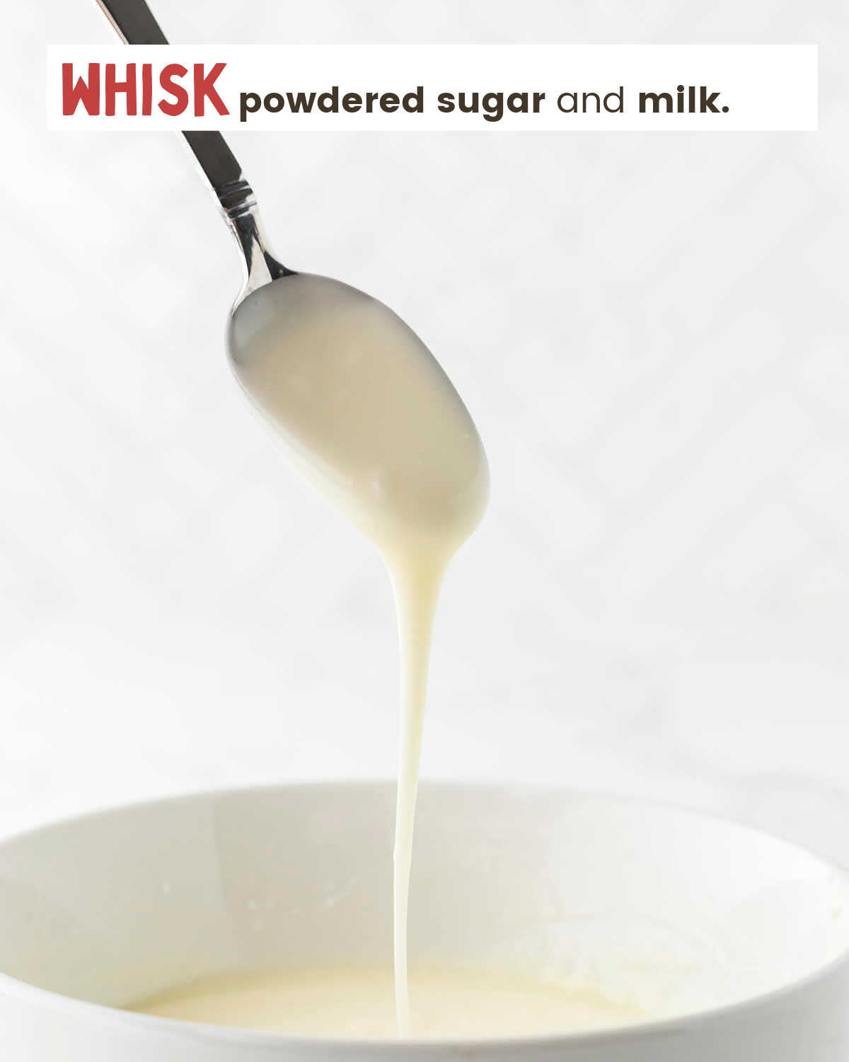Milk is drizzling from a spoon into a bowl.