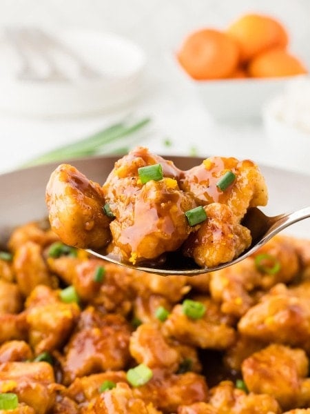 Closeup of a serving spoon of homemade Orange Chicken.