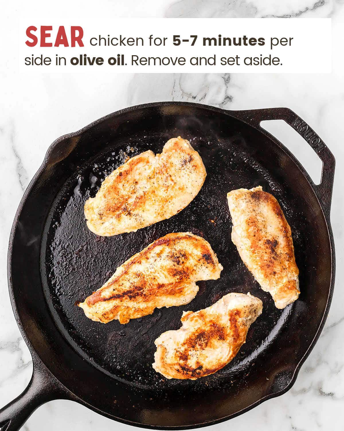 Seared chicken breasts in a cast iron skillet.