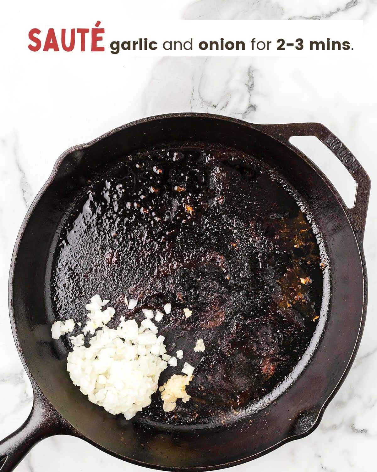 Chopped onion and garlic in a cast iron skillet.