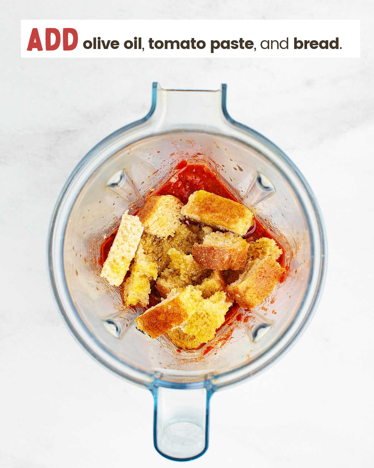 A red sauce is topped with bread in a blender.