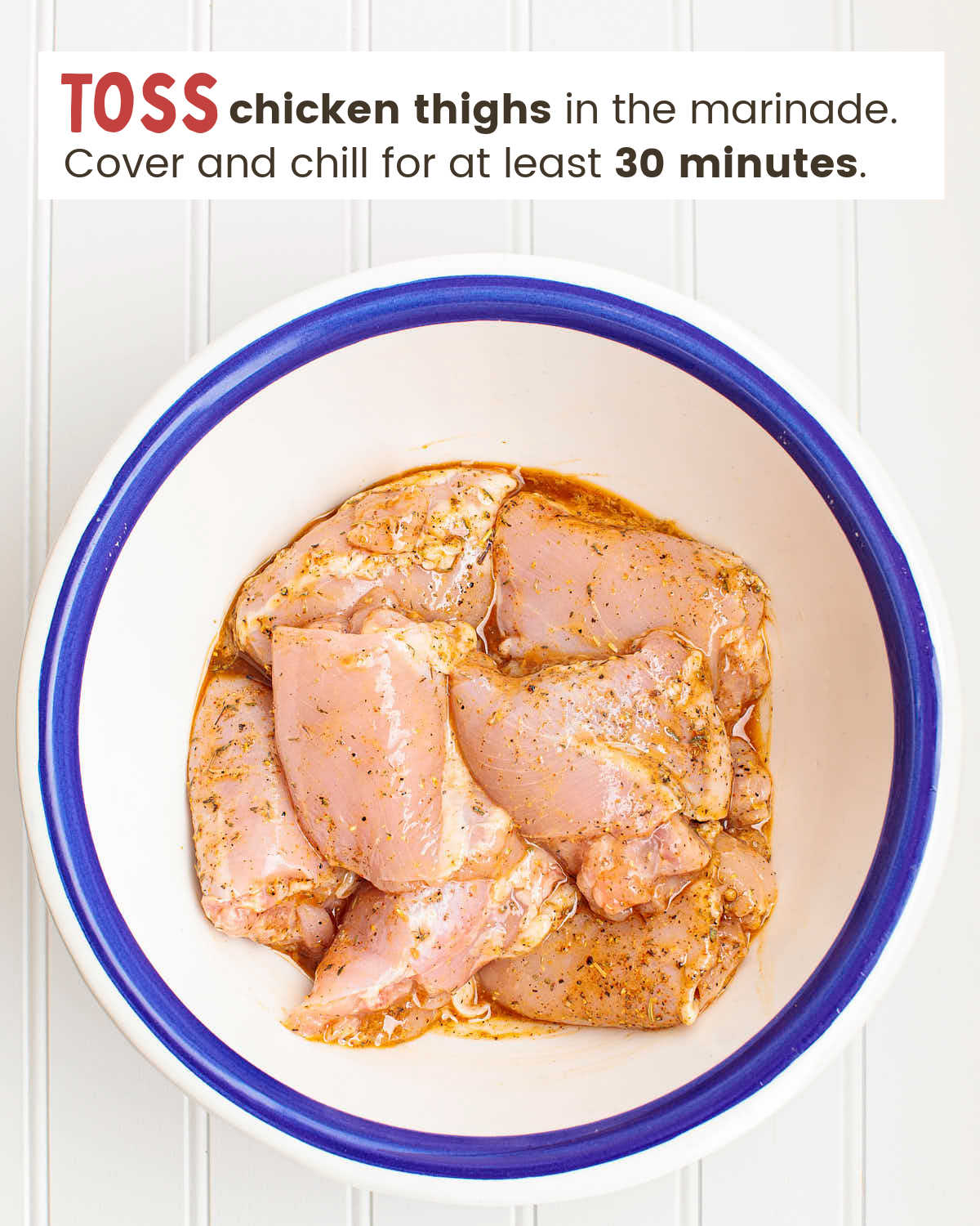Chicken thighs in a marinade in a bowl.