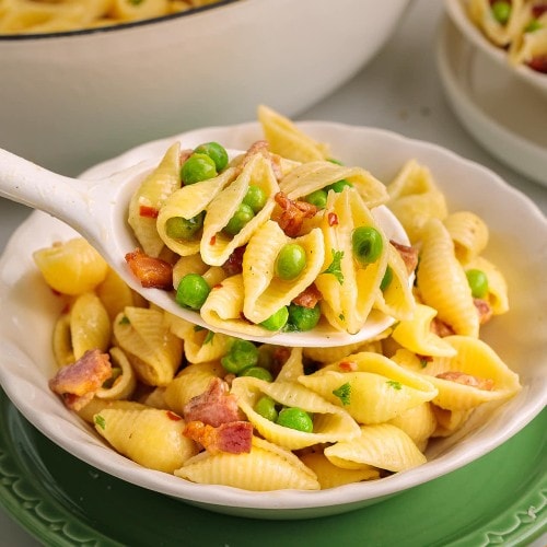 A serving spoonful of creamy Bacon Pasta with Peas.