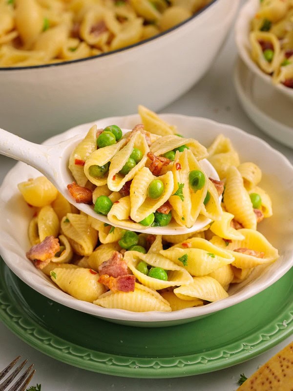 A serving spoonful of creamy Bacon Pasta with Peas.