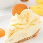 A slice of no-bake Banana Cake served on a white plates with extra Nilla wafers.