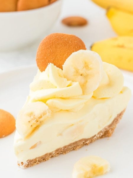 A slice of no-bake Banana Cake served on a white plates with extra Nilla wafers.