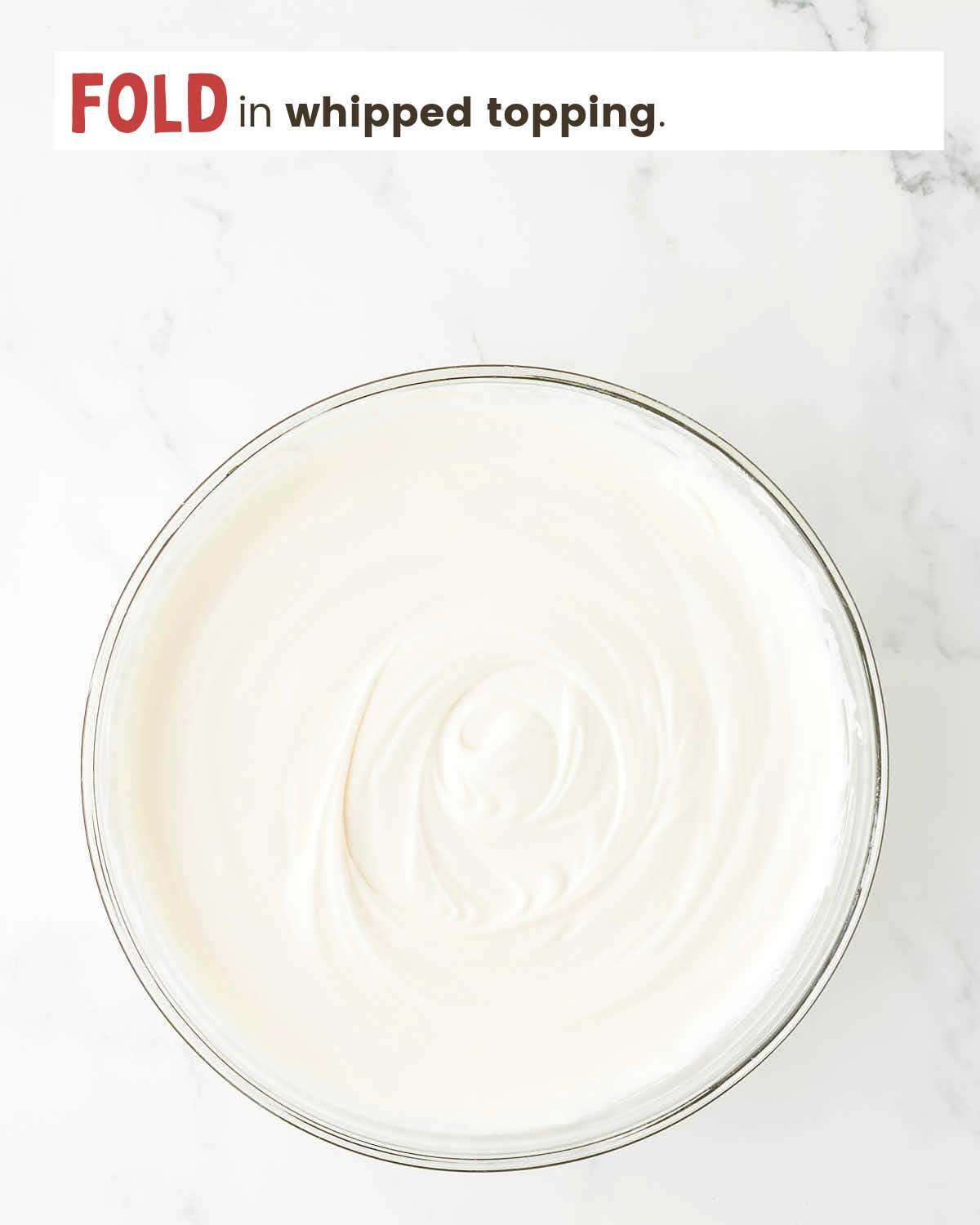 Pudding mixture with whipped topping folded in in a bowl.