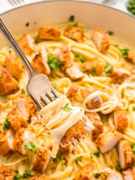 Blackened Chicken Alfredo with parsley and cheese.