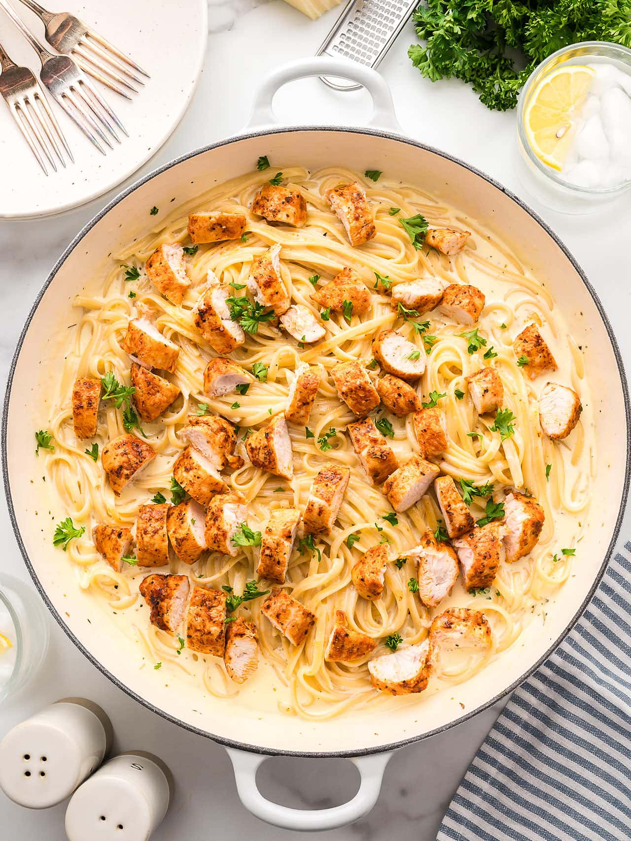 Blackened Chicken Alfredo and pasta in a white pan.