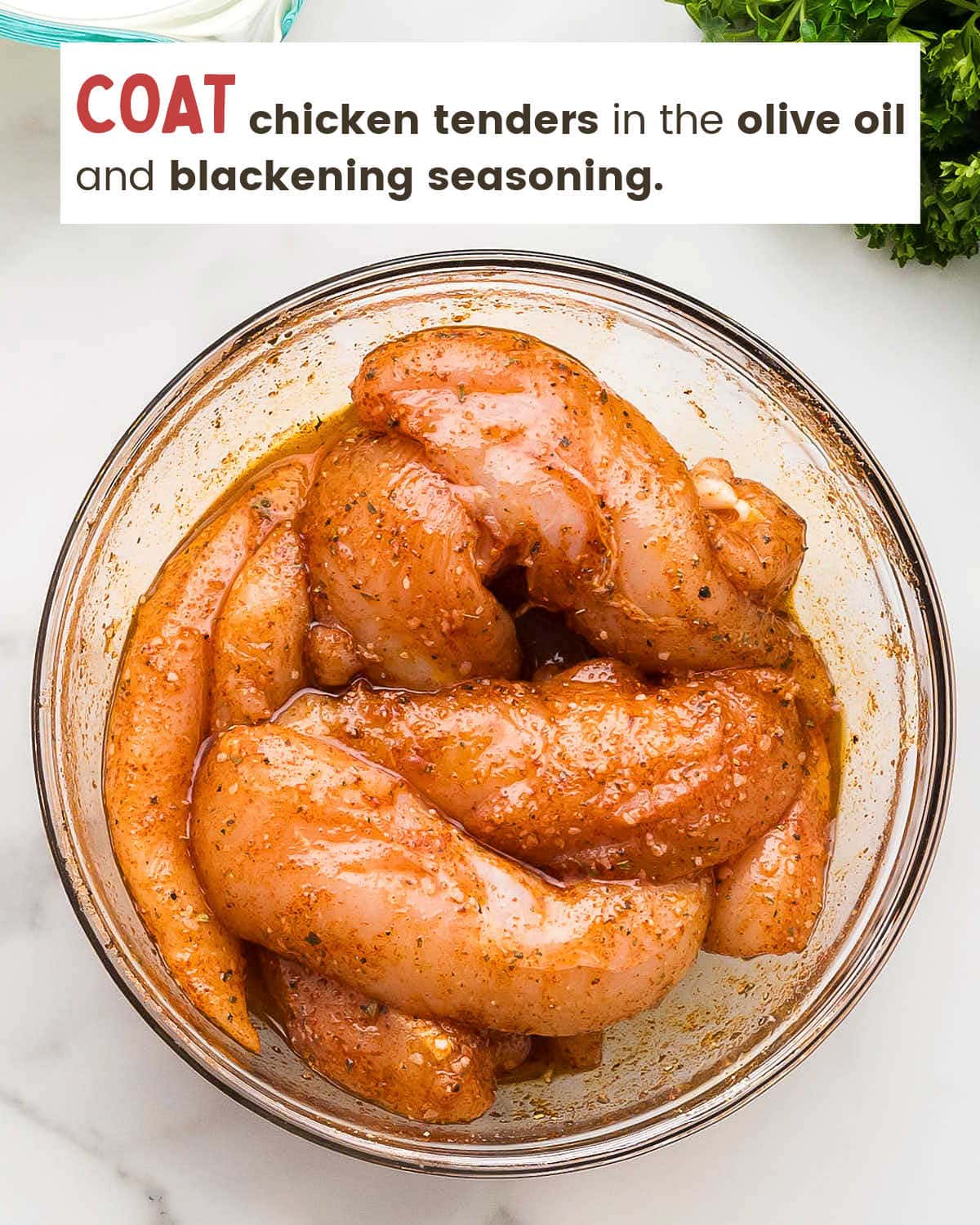 Chicken tenders coated in blackening seasoning paste in a glass bowl.
