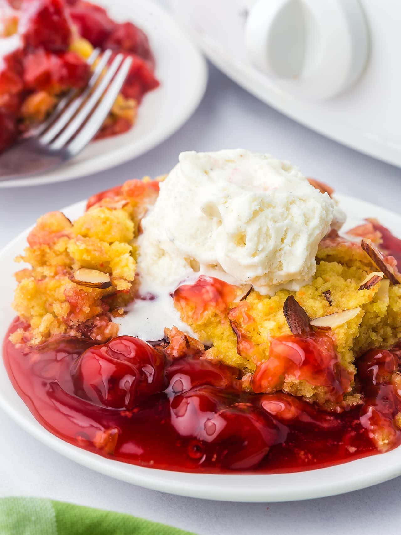 A spoon full of Crock Pot Cherry Dump Cake is being held up.