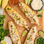 Top down view of Elote served with extra cheese, lime wedges, and cilantro.
