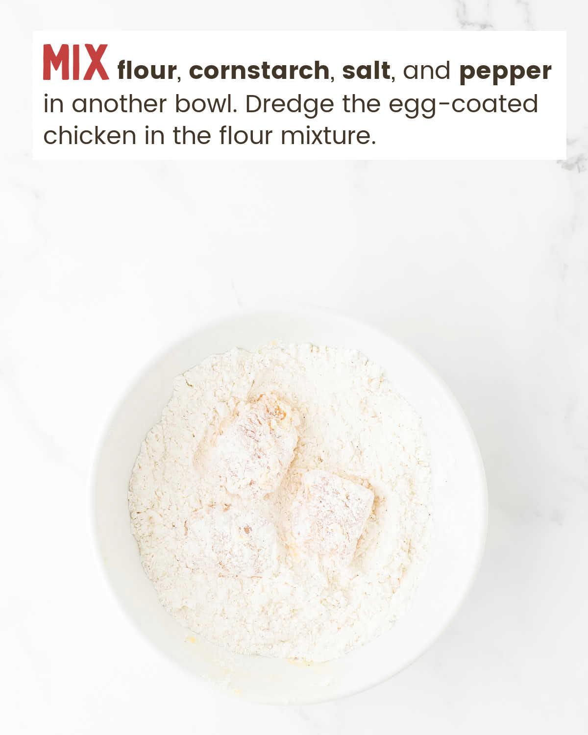 Chicken pieces in a flour mixture in a bowl.
