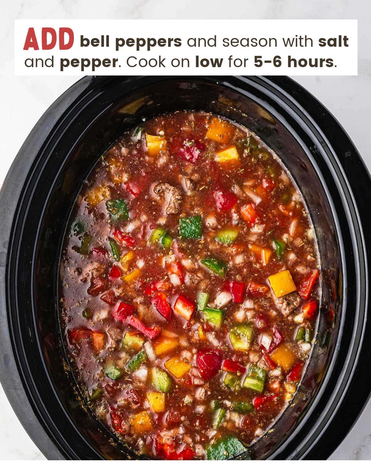Chopped bell peppers in broth along with other ingredients to make stuff pepper soup in a slow cooker.
