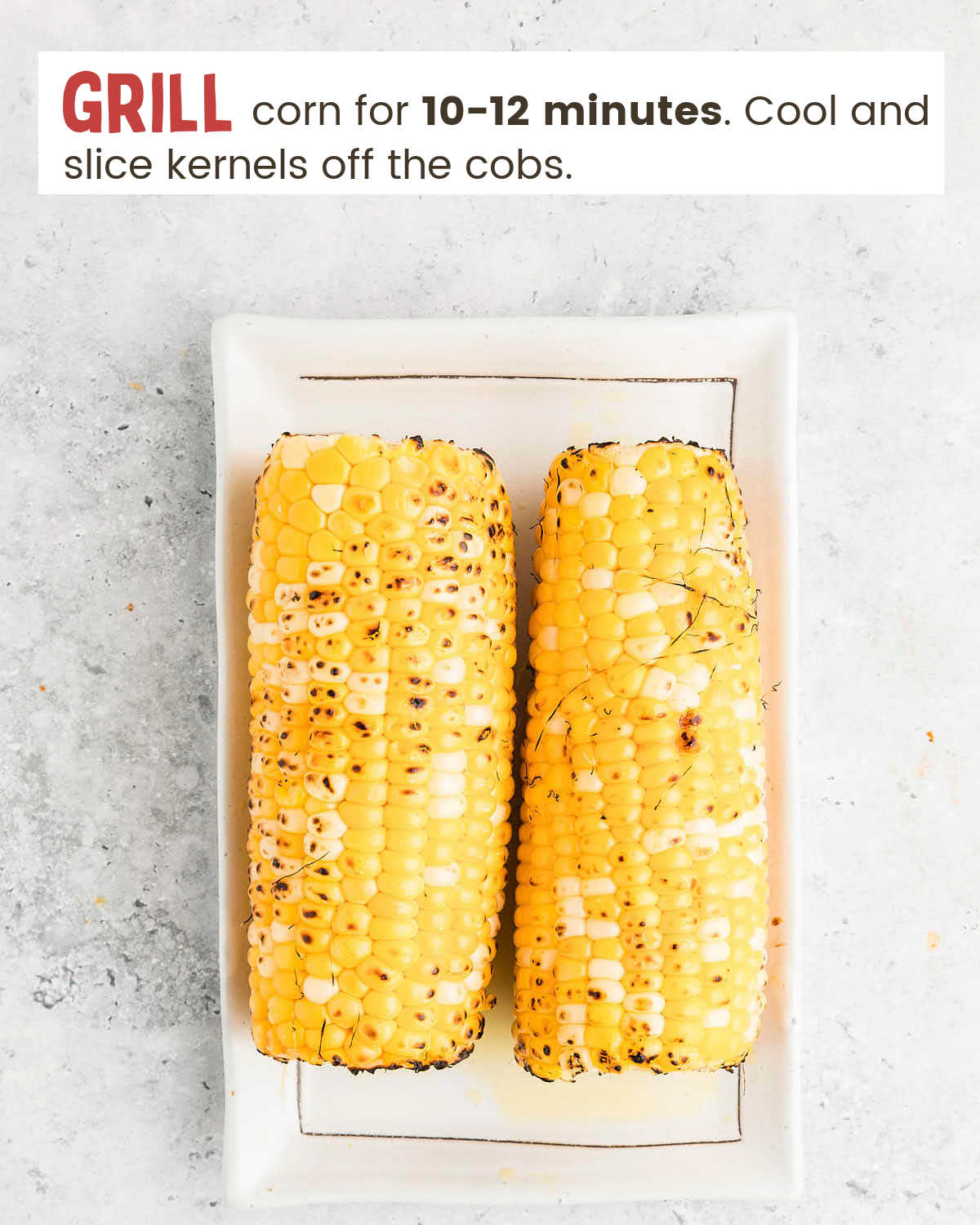 Two ears of grilled corn on a white plate.
