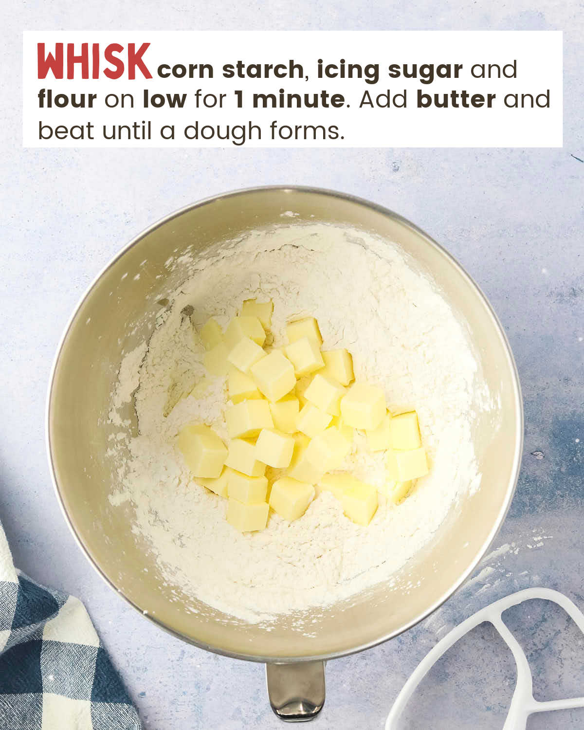 corn starch, icing sugar, flour, and butter cubes in a mixing bowl. 