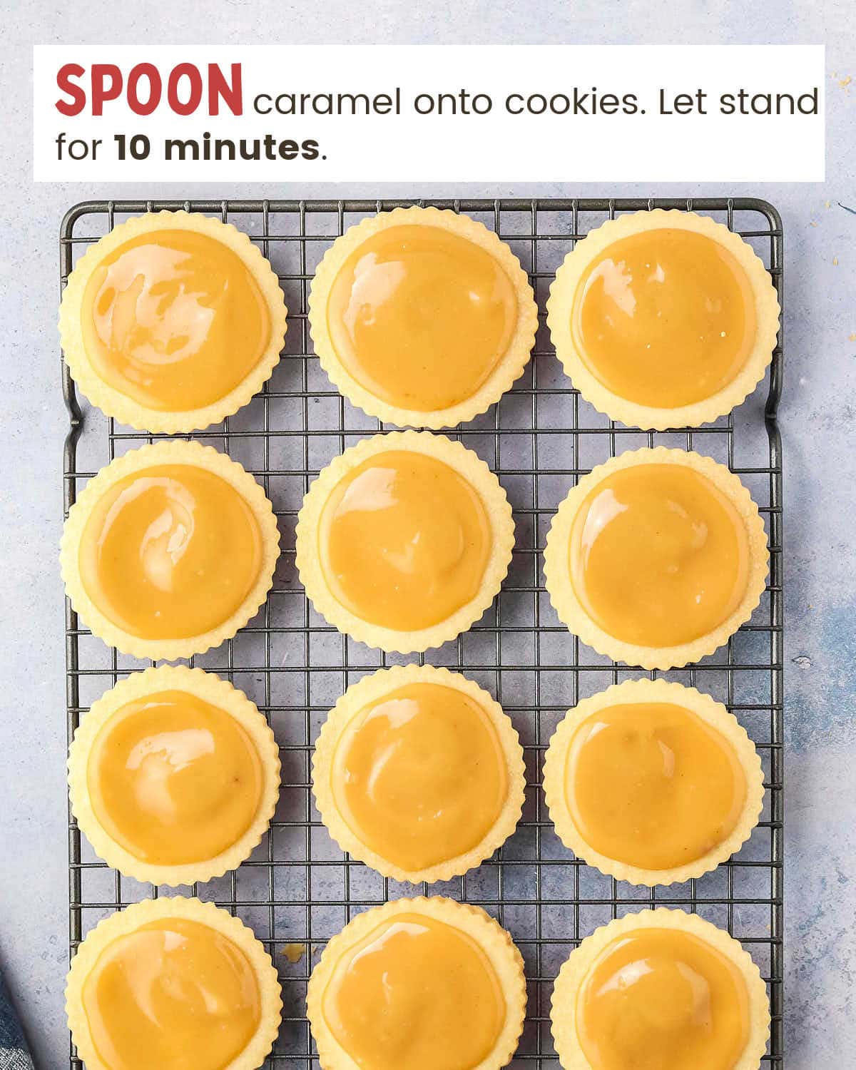 Caramel on round cookies on a cooling rack.