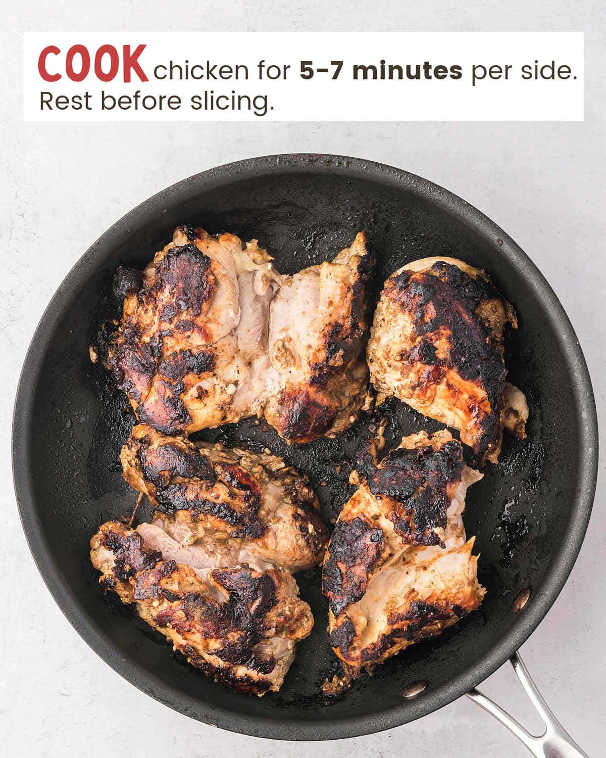 Chicken pieces fried in a skillet.