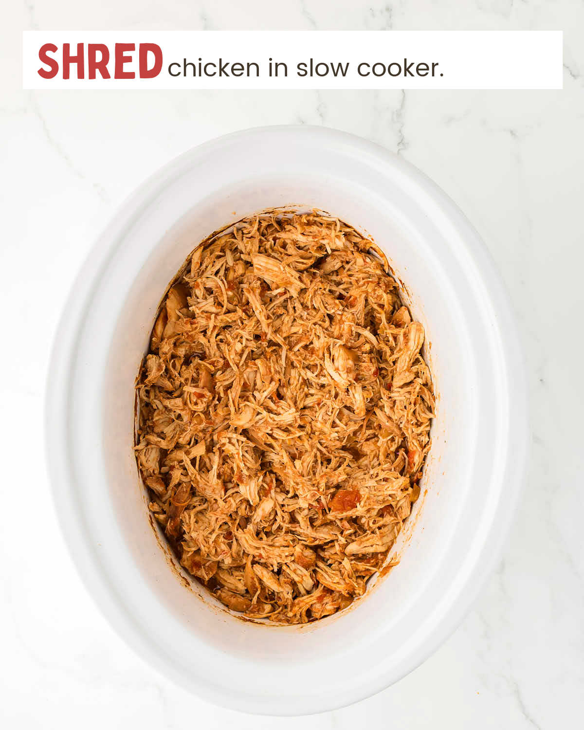 Shredded crockpot salsa chicken in a slow cooker.