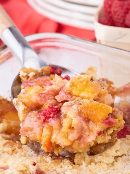 A serving spoonful of Peach Melba Dump Cake.