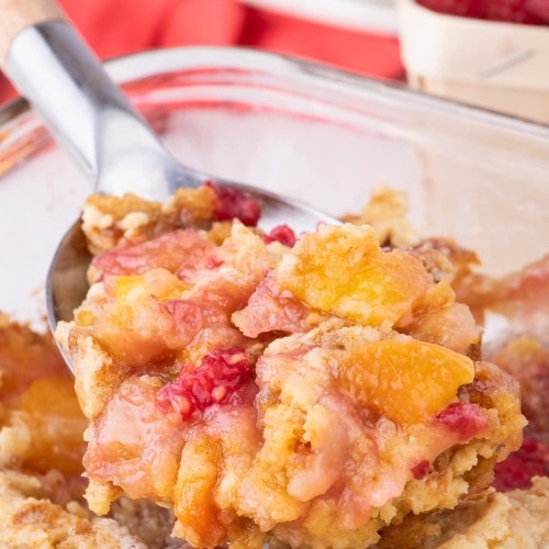 A serving spoonful of Peach Melba Dump Cake.