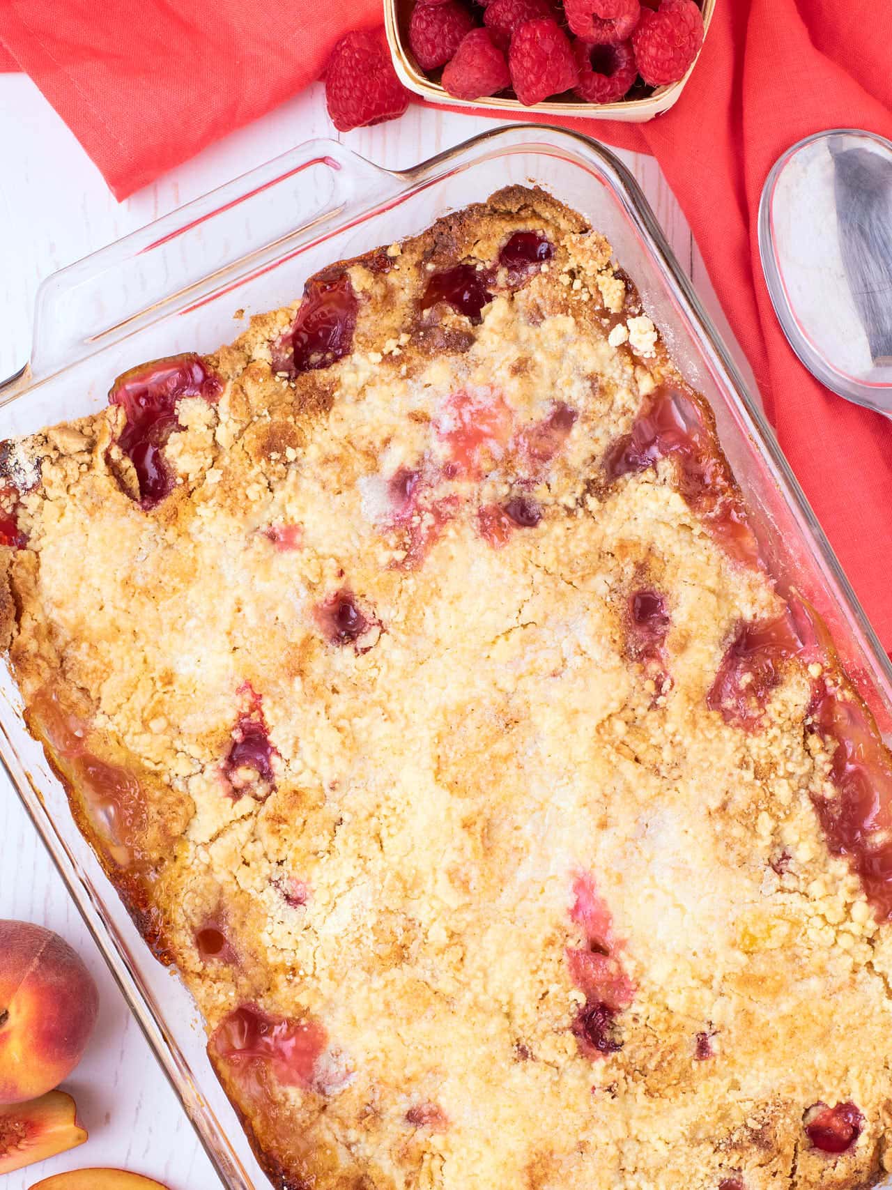 Topdown view of a Peach Melba Dump Cake in glass baking dish.