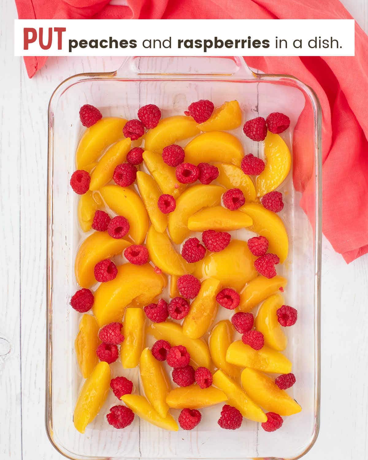 Peach slices and raspberries in a 9x13" glass dish.