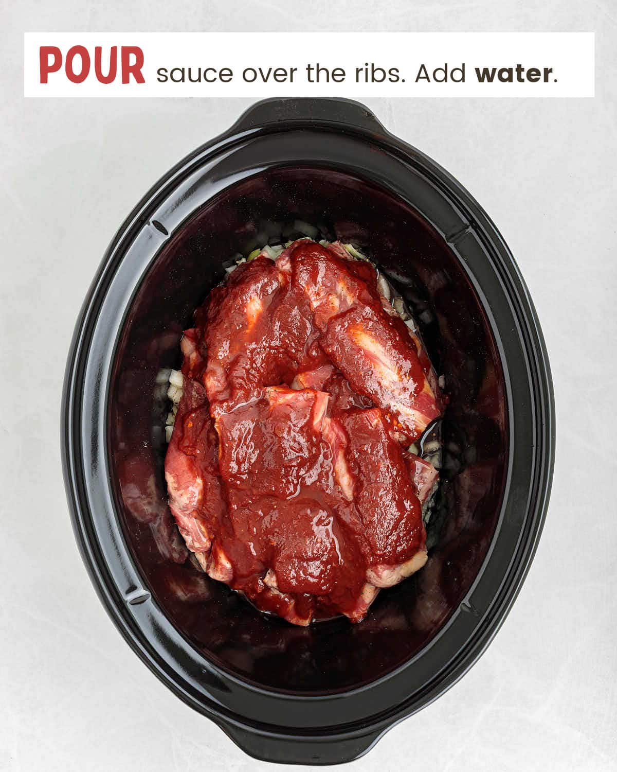 Sauce poured over beef ribs in a slow cooker.