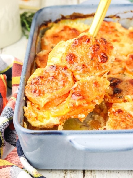 Lifting a Sweet Potato Gratin out of a casserole dish.