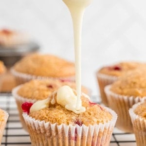 Pouring glaze over the Orange Cranberry Muffins.