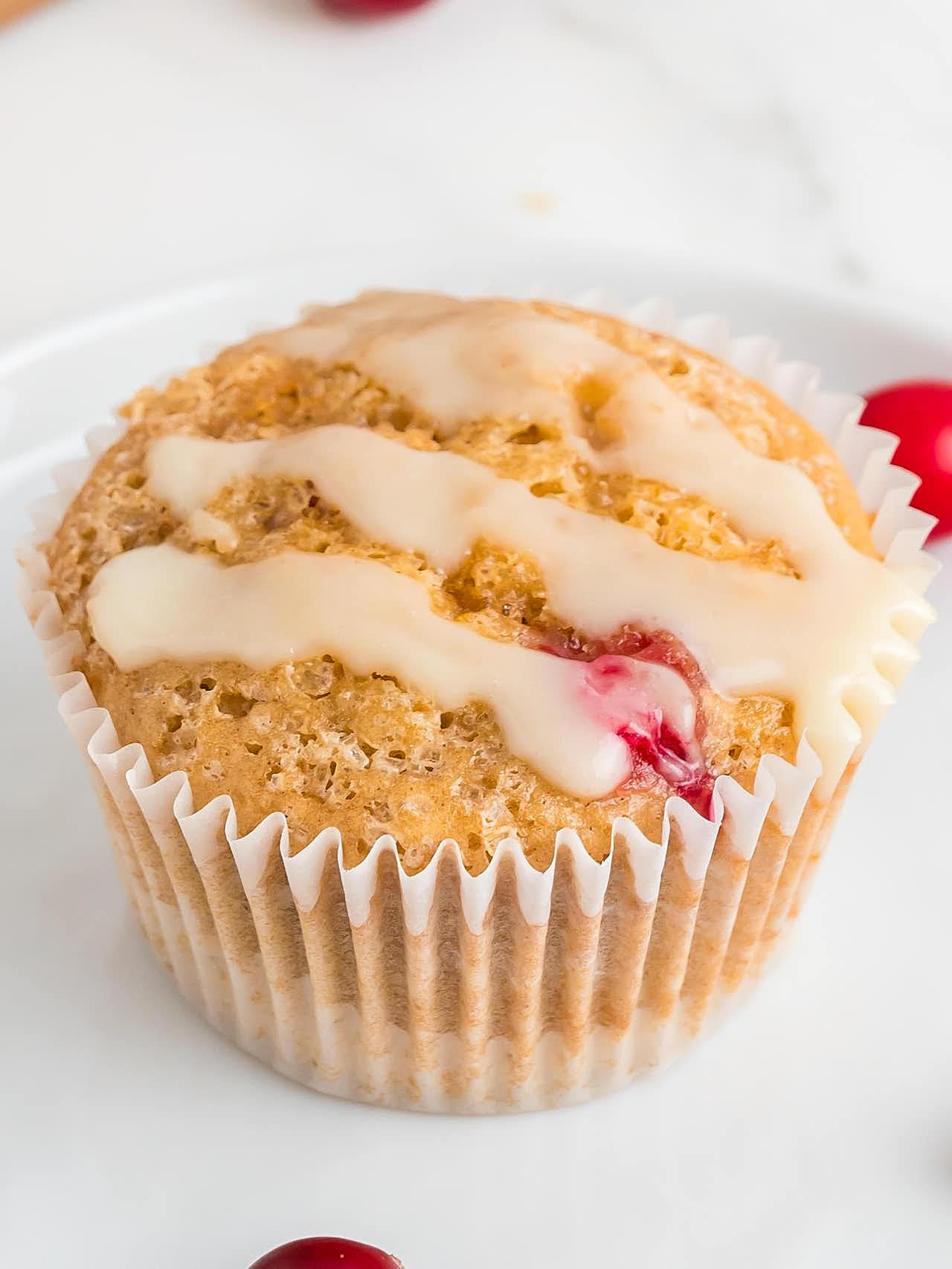 Closeup of a glazed Cranberry Orange Muffin.