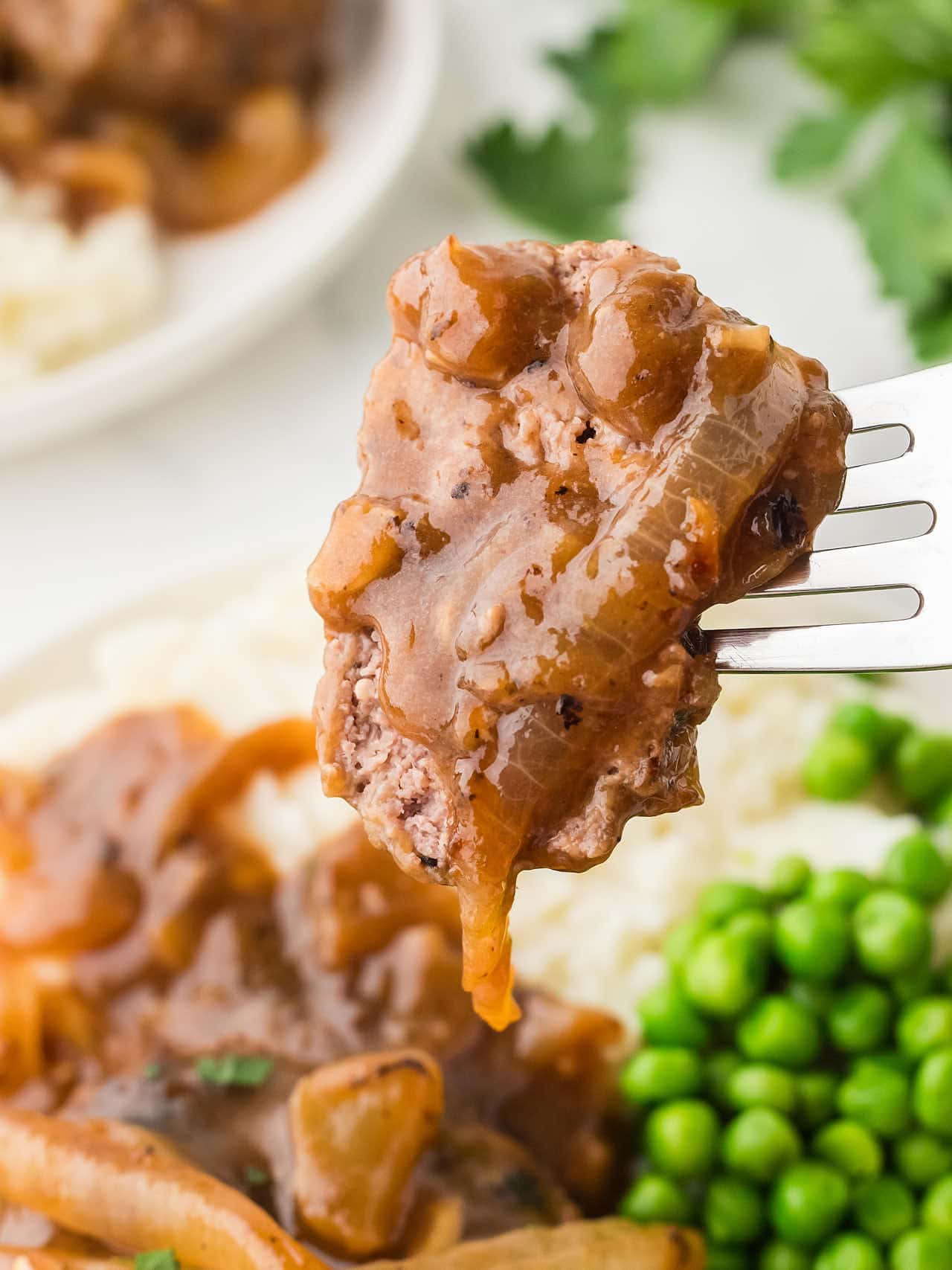A forkful of Hamburger Steak.