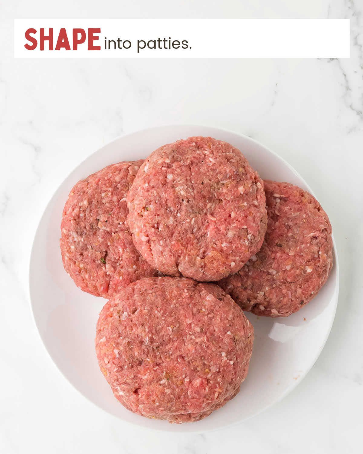 Ground beef patties stacked on a white plate.