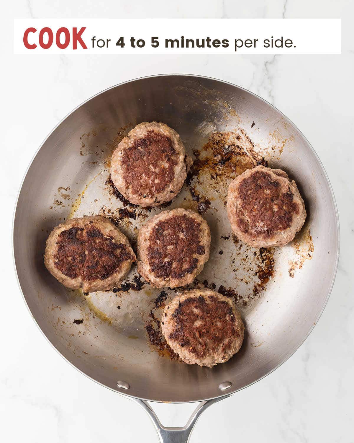 Five cooked ground beef patties in a skillet.