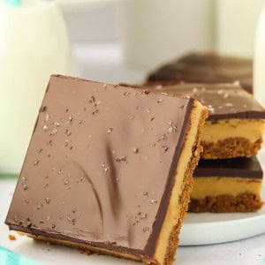 A slice of Millionaire Shortbread leaning against a white plate.