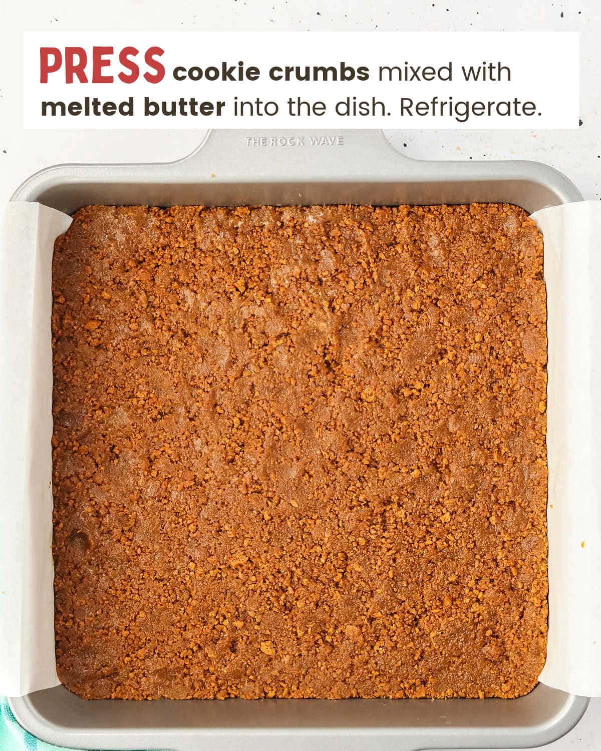 Cookie crumbs mixed with melted butter pressed into a dish lined with parchment paper. 