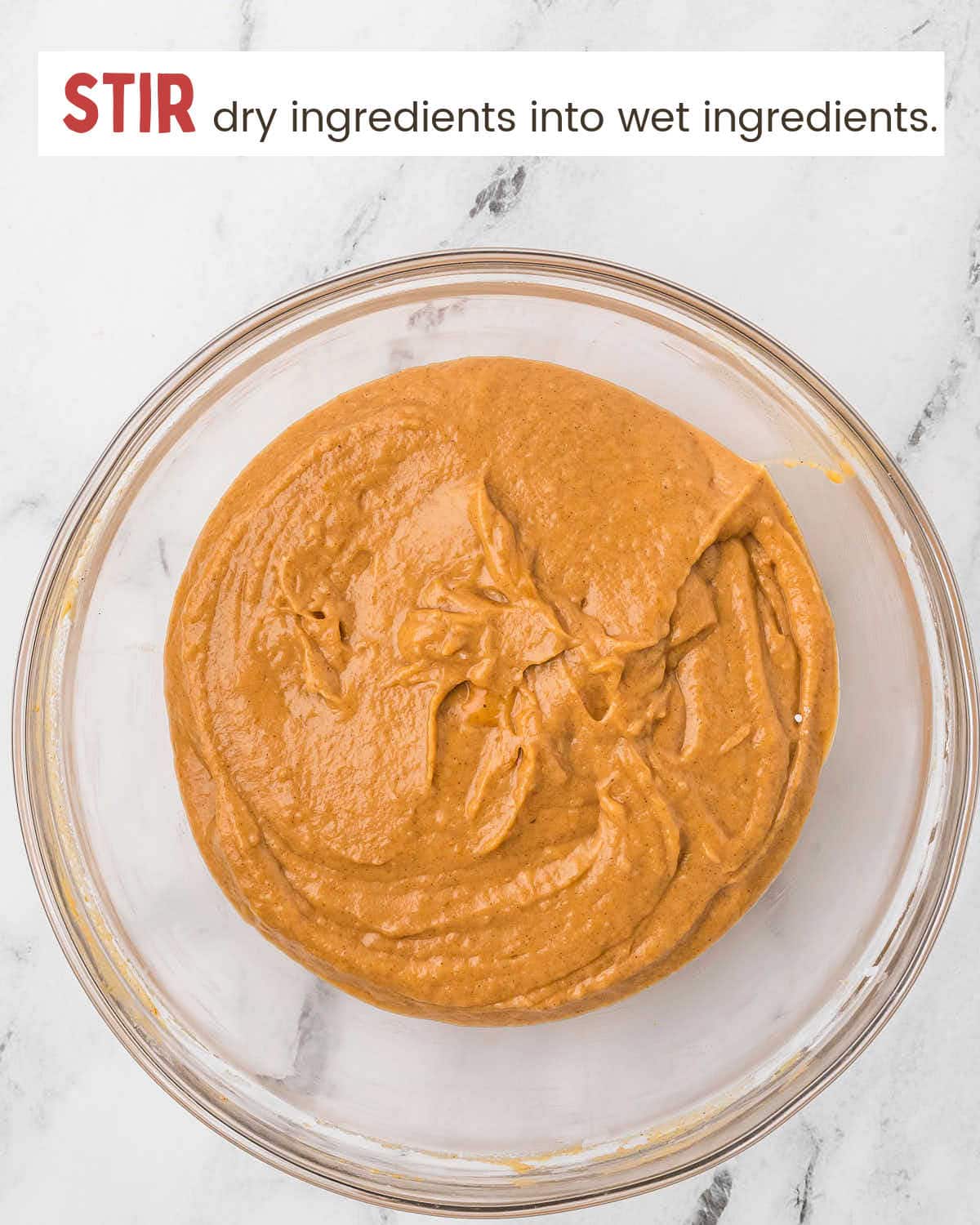 Pumpkin muffin batter in a glass bowl.