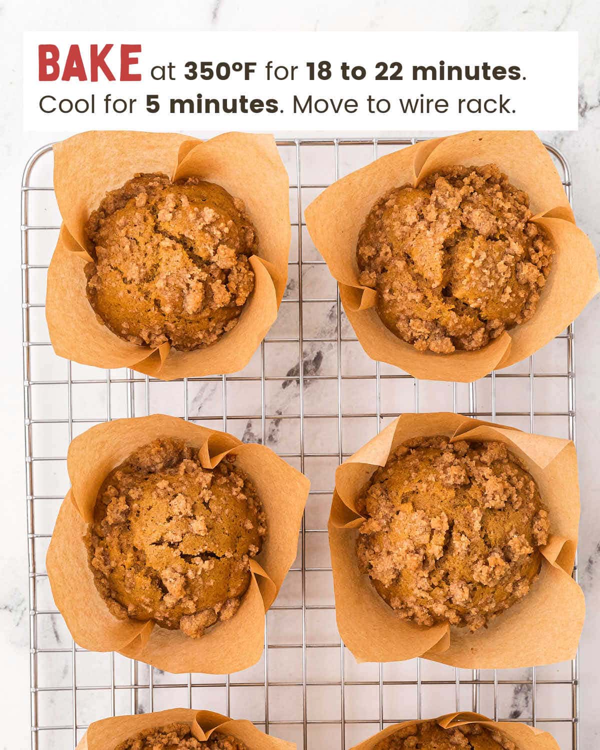 Pumpkin muffins topped with streusel in muffin tin cups lined with parchment paper.