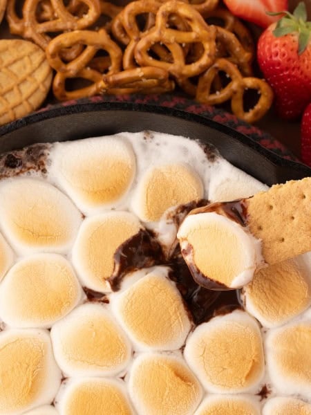 Scooping the S'mores Dip with a cookie.