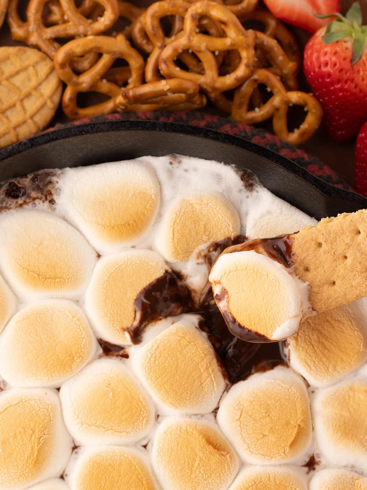 Scooping the S'mores Dip with a cookie.