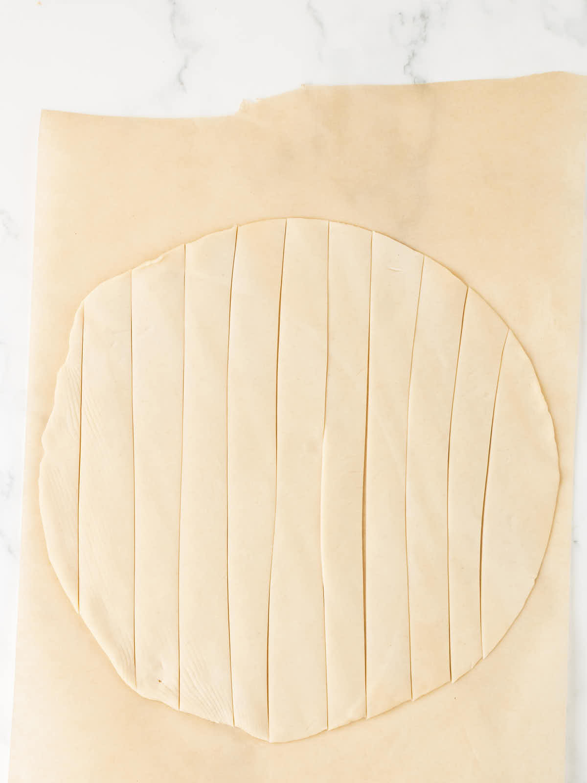 Unbaked pie crust sliced into strips.