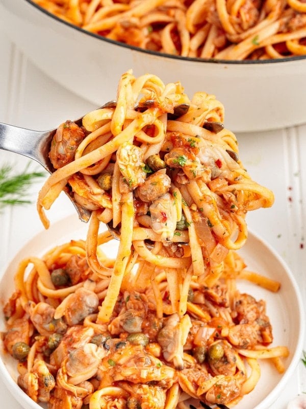 A serving spoon full of Linguini with Clams.