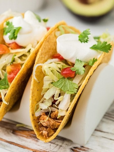 Turkey Taco in a hardshell taco topped with lettuce, onion, and sour cream.