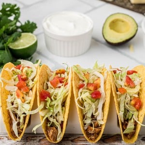 Hard shell turkey tacos filled with shredded lettuce, diced tomatoes, and seasoned leftover Thanksgiving turkey.