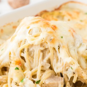 Creamy Turkey Tetrazzini with spaghetti, turkey, mushrooms, and melted cheese being served from the pan.
