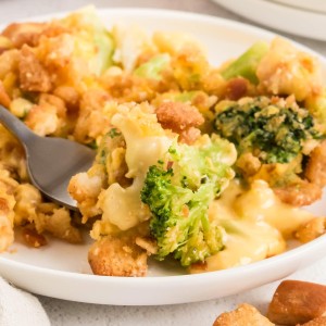 A close-up of broccoli and cauliflower baked in creamy cheese sauce with a crunchy stuffing topping in the Broccoli Cauliflower Casserole.