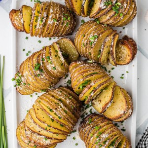 Freshly baked Hasselback Potatoes served on a white plate.